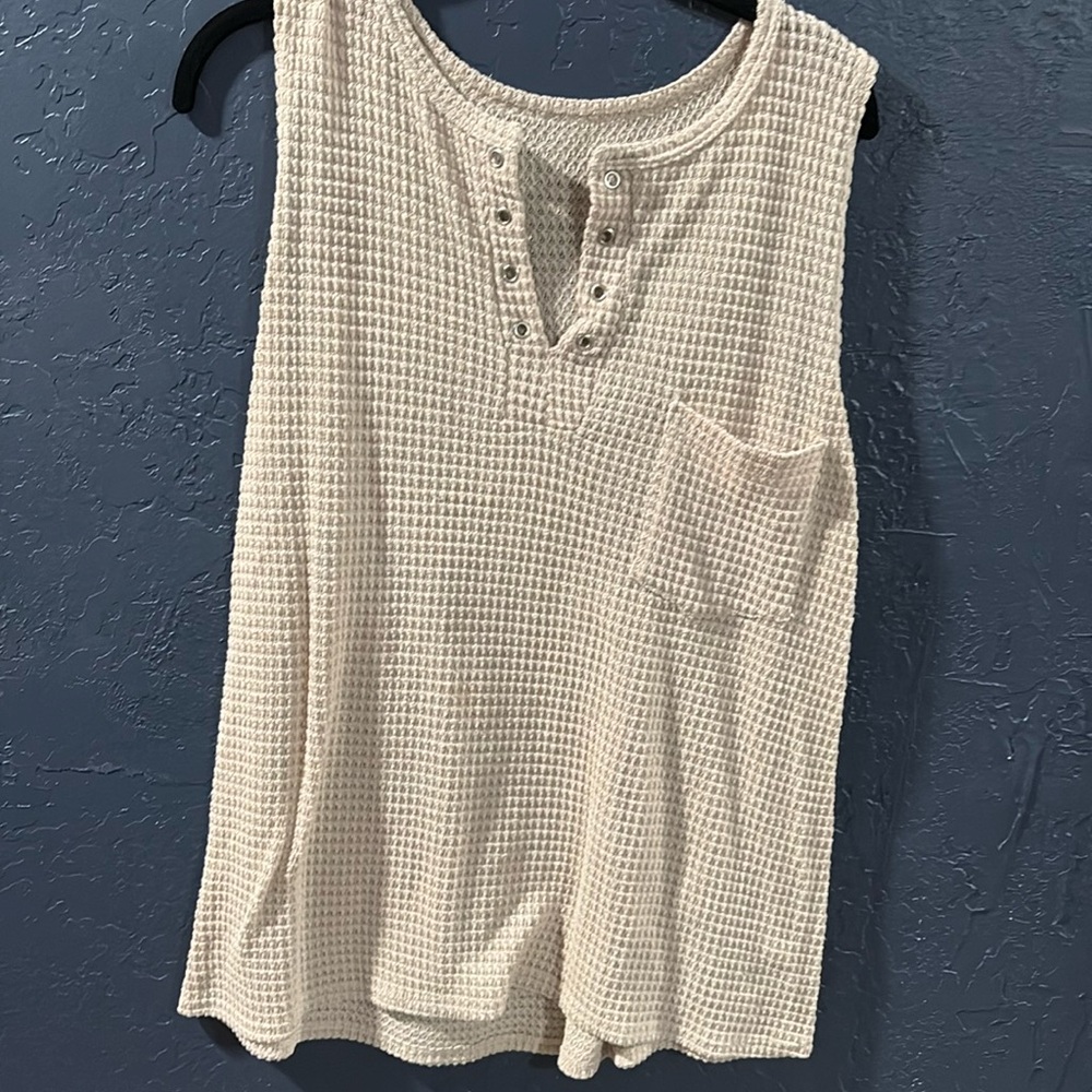 Cream colored woven top with eyelets and front pocket